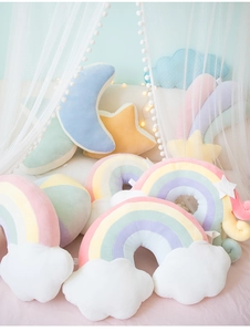 Cozy macaron-colored star and moon plush cushions set in a dreamy bedroom scene