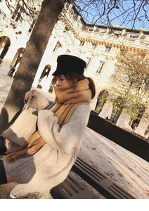 Outdoor shot of cozy thick camel mohair scarf paired with a grey knit sweater and black cap