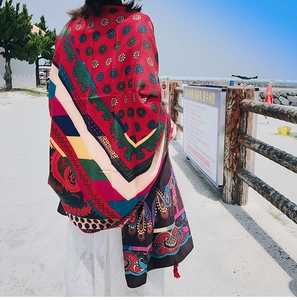 Detail of red Bohemian shawl with ethnic paisley patterns and fringe tassels