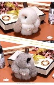 Close-up of plush rabbit keychain with gold metal clasp and soft faux mink fur texture