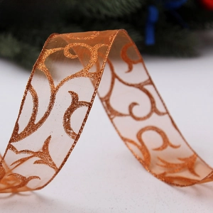 Macro view of bronze sheer glitter ribbon with scroll patterns for Christmas tree decor