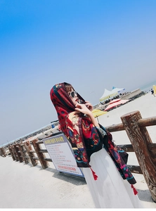 Close-up of red bohemian paisley print shawl with decorative tassels for beach wear