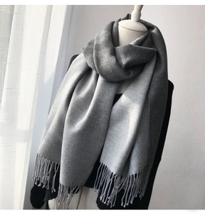 Detailed view of gray cashmere-like shawl featuring soft texture and fine fringe tassels