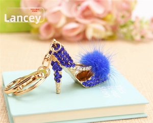 Detail of royal blue high heel keychain with faux fur pompom and sparkling crystals
