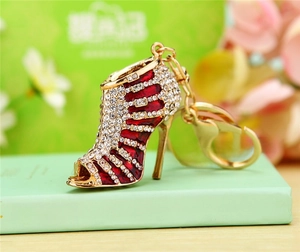 Macro detail of red stiletto keychain with sparkling white rhinestones and gold plating