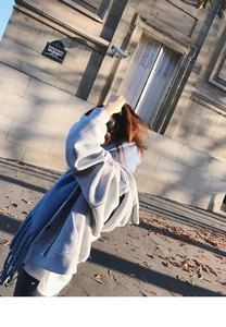 Detailed view of grey zip-up hoodie paired with a soft blue mohair fringe scarf