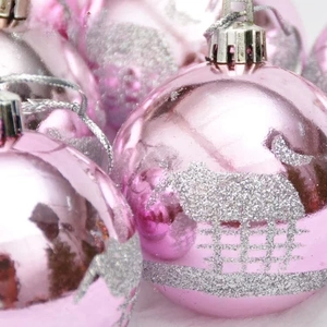 Close-up of pink glitter Christmas ball ornaments with silver reindeer and snow scene