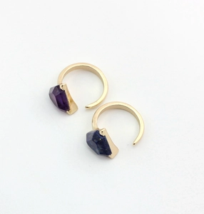 Macro view of gold-plated rings inlaid with natural amethyst and lapis lazuli stones