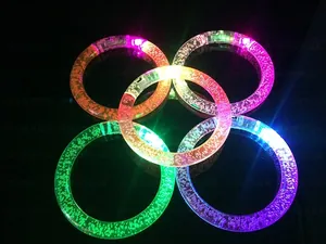 Detail of five colorful LED glowing acrylic bubble bracelets in dark environment