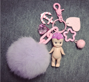Detailed view of purple faux fur pompom keychain with pink cute charms and metal lobster clasp