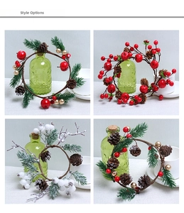 Detail view of four Christmas candle rings with pine cones, red berries and snow finish