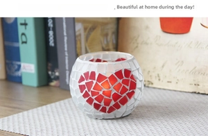 Detailed view of handmade mosaic glass candle holder with red heart pattern on a mat
