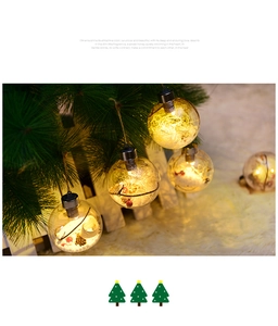 Detail of clear 8cm LED Christmas ball with warm pinecone and berry decor inside