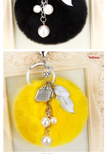 Détail du porte-clés pompon en fausse fourrure avec perles et étiquette vintage