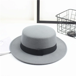 Detail view of a gray wool felt flat top hat with a black decorative ribbon and ribbon bow