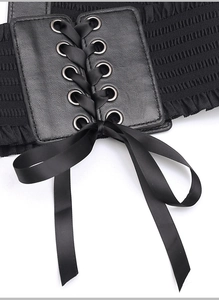 Close-up view of the black corset belt showing metal eyelets and delicate satin ribbon bow.