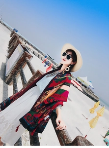 Detail of red Bohemian print shawl with intricate geometric patterns and tassel trim