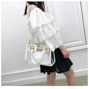 Transparent PVC beach bag with white trim and gold hardware details on shoulder