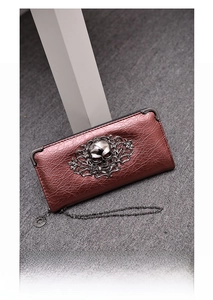 Macro view of metallic rose gold leather wallet with 3D skull and relief detail