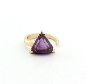 Macro detail of a gold open ring featuring a triangular purple amethyst stone inlay