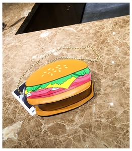Detail view of the hamburger-shaped bag with layered design and gold metal chain
