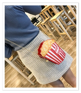 Detail of creative popcorn shaped crossbody bag with red and white stripes and gold chain