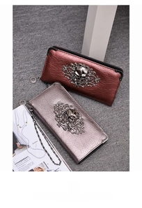 Close-up of gothic skull ornaments on red and silver metallic faux leather wallets