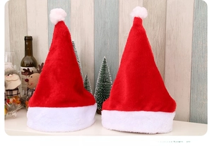 Detail of two classic plush red and white Christmas hats with soft pom-poms on top