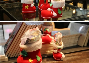 Detail of red Christmas boot gift bags in various sizes filled with holiday candies and snacks