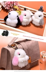 Detail of fluffy mink fur rabbit charm attached to a pink crocodile leather handbag