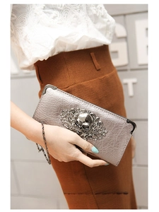 Detail of silver skull and floral embossed long wallet with metallic chain strap
