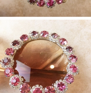 Macro shot of circular fashion sunglasses with layered pink rhinestones and metal base