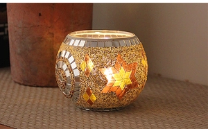 Detailed view of spherical mosaic glass candle holder with glowing star patterns