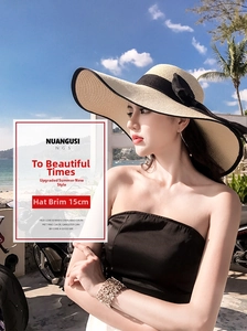 Detail showing a 15cm wide brim straw sun hat with an elegant black ribbon bow