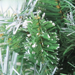 Detailed macro view of green artificial Christmas tree branches with white snowy flocking