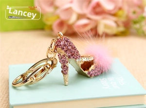 Detail of pink crystal high heel keychain with a soft faux fur pompom and gold lobster clasp