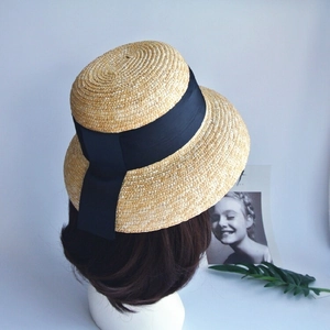 Detail of French vintage straw cloche hat with black ribbon and elegant fishtail bow