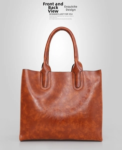 Macro shot of brown oil wax leather texture and stitching on a large tote bag