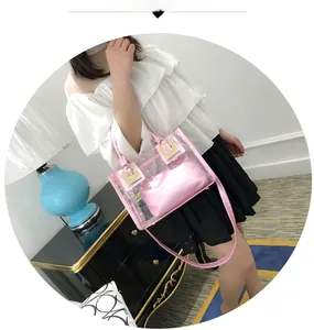 Detail of pink jelly beach bag with transparent PVC exterior and inner pouch on a model