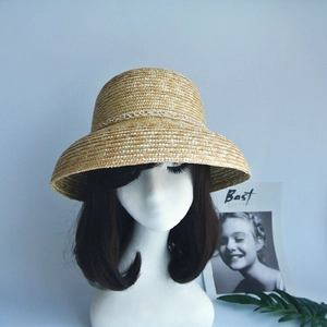 Detail of hand-woven natural straw bucket hat with textured weave and ribbon trim