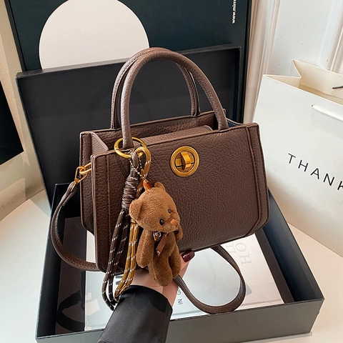 Damen Handtasche Retro Litschi Muster PU Leder Schulter Umhängetasche Mit Goldenem Drehverschluss Und Plüschbär Anhänger