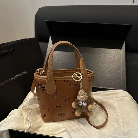 Women Crossbody Bucket Bag PU Leather Embossed Handbag With Plush Monster Charm Removable Strap Urban Minimalist