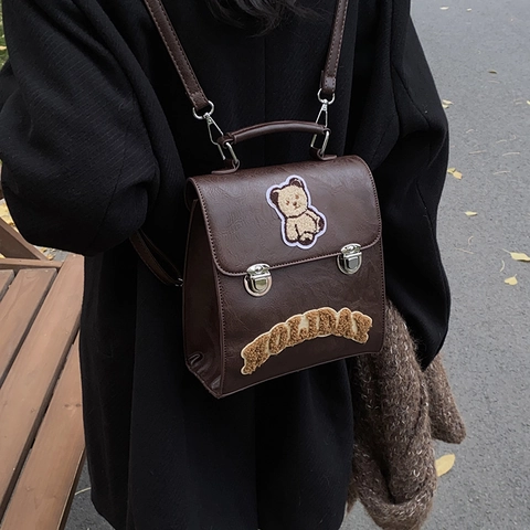 Mochila de Cuero PU Vintage para Mujer con Parche de Oso de Dibujos Animados y Bordado Holiday Estilo Universitario Bolso Escolar