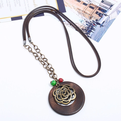 Collier Long Ethnique Vintage Bohème pour Femmes Anneau en Bois Pendentif Fleur Creuse en Alliage de Bronze Cordon Tissé