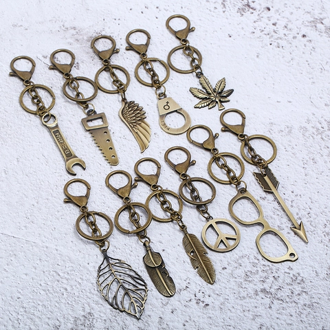 Portachiavi in Metallo Bronzo Antico Vintage Lega di Zinco Foglia Piuma Ala Manette Sega Chiave Inglese Pendente per Borsa
