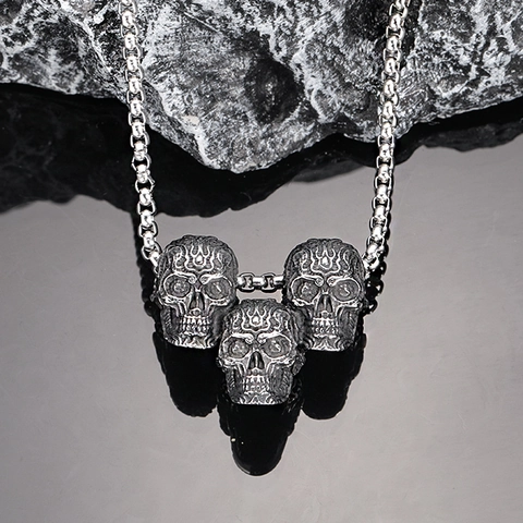 Collana da Uomo Vintage Gothic in Acciaio al Titanio con Pendente a Triplo Teschio Dettaglio Fiamma Incisa Finitura Argento Antico