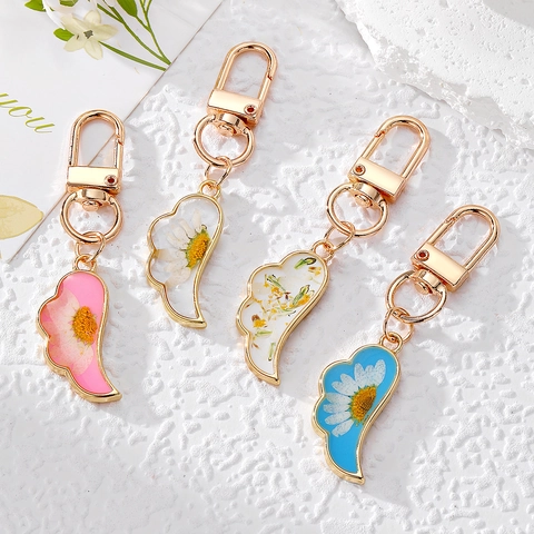 Porte-clés Fait Main en Résine Fleur Séchée Marguerite Ailes Style Pastoral Pendentif d'Aile Florale Porte-clés pour Sac à Bijoux Décoration