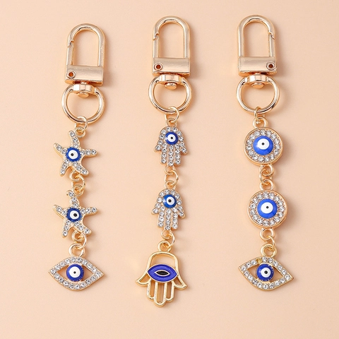 Modischer Gold Galvanisierter Zinklegierung Böser Blick Schlüsselanhänger Mit Seestern Hand Der Fatima Strass Emaille Taschenanhänger