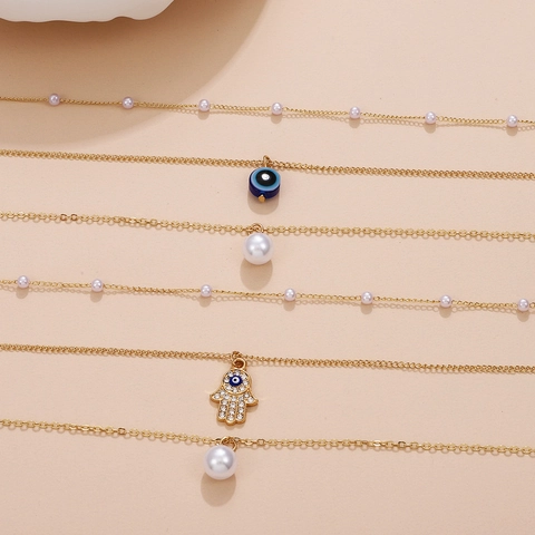Collier Multirang en Alliage et Künstliche Perles Synthétiques avec Pendentif Mauvais Œil Main de Fatma Papillon Croix pour Femme Bijoux Mode