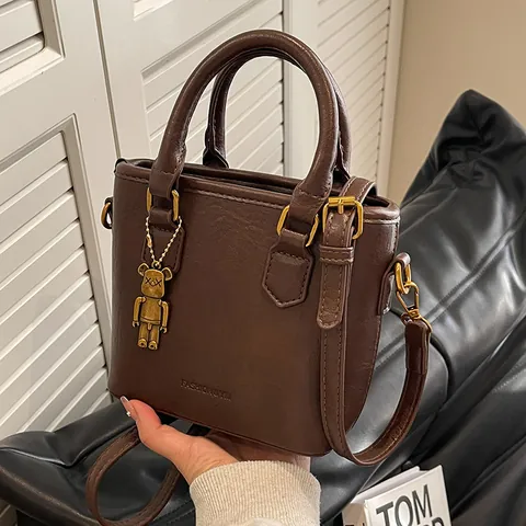 Bolso de Cubo de Cuero PU Vintage Para Mujer Bolso de Mano y Bandolera Diseño de Nicho Con Colgante de Oso Color Contraste